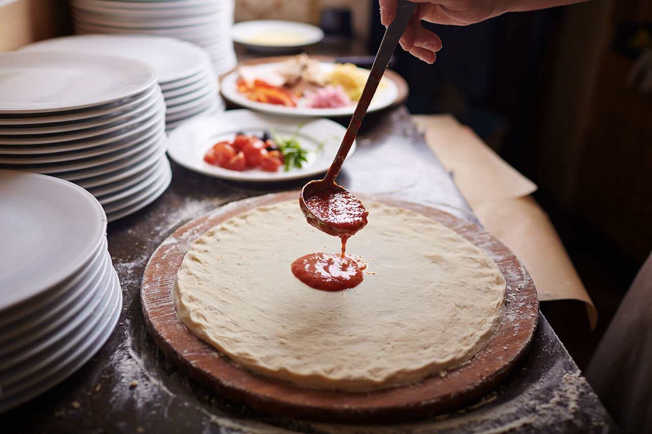 Hands preparing pizza dough — Seven Oaks cooking class